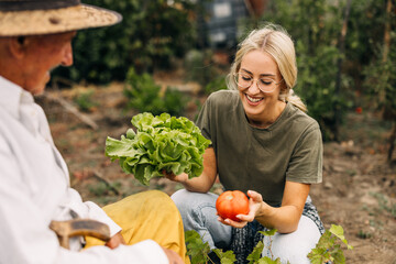 Happy young woman in the garden, holding organic vegetables.