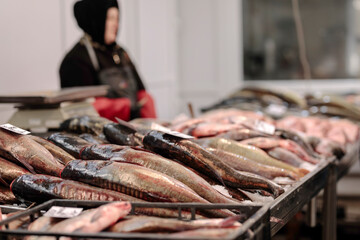 A Fishy Feast: A person standing in front of a table full of fresh, colorful, and delicious fish