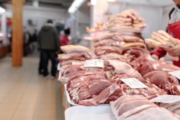 A Man Standing in Front of a Counter Filled with Meat