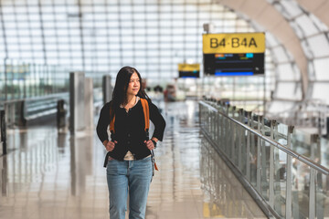 Airport terminal, happy woman backpacker walking at airport passenger waiting hall. - obrazy, fototapety, plakaty