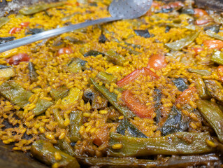 Spectacular detail shot and tasty vegetable paella, a small sheet of rice that is no thicker and with mushrooms, peppers, asparagus, beans and more, rice and a typical dish from Valencia in Spain