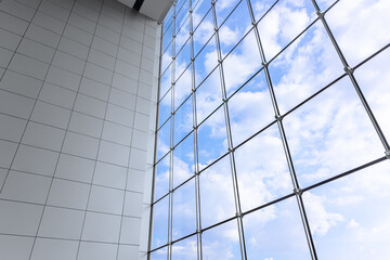 Fototapeta na wymiar Large windows blue sky of modern business office building in metropolitan. Interior shopping mall glass frame window saving energy lighting design.