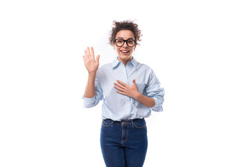 pretty slender young brunette curly employee of the company woman dressed in a light blue shirt and...