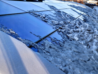 roof windows clogged with snow. roofing of greenhouse or atrium. snow is melting and coming down, sliding down and glass is cleaned to be clean they are waiting for snow to melt down, polar climate