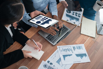 Multiracial analyst team use BI Fintech software to analyze financial data on meeting table....