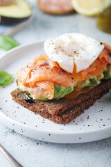 A rye bread sandwich with avocado and salmon