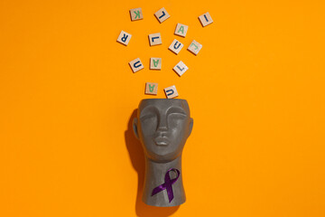 Ancient stone human head with wooden letters
