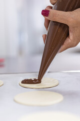 piping bag putting chocolate to cooking dough