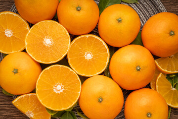 Fresh Orange fruit in wooden basket on wooden background.