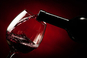 Bottle filling the glass of wine - splash of delicious flavor. - 692926392