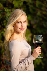 Woman drinks red wine in vineyard - 692926733