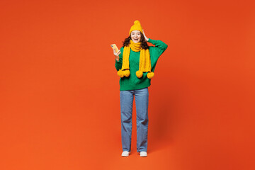 Full body young surprised excited happy woman she wear green knitted sweater yellow hat scarf hold...