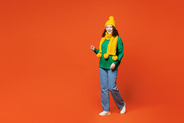 Full body side view young smiling cheerful happy woman she wear green knitted sweater yellow hat...