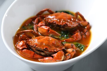 Delicious boiled crabs with sauce on table, closeup