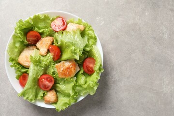 Delicious salad with chicken and cherry tomato on light grey table, top view. Space for text