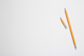 Graphite pencils on white background, flat lay. Space for text