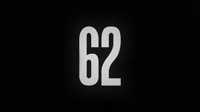 The number 62 smolders and burns on a black background, the number is on fire