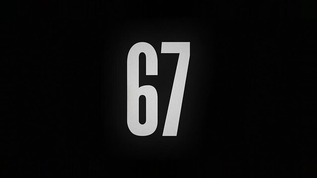 The number 67 smolders and burns on a black background, the number is on fire