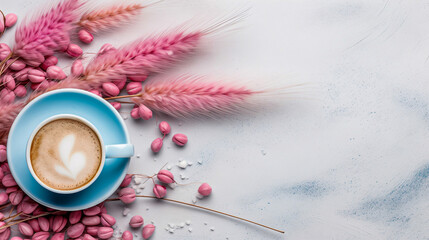 Obraz na płótnie Canvas Light blue cup of cappuccino from above with latte art, dried pink leaves and grasses, on a slate stone, coffee beans, isolated on a white background.