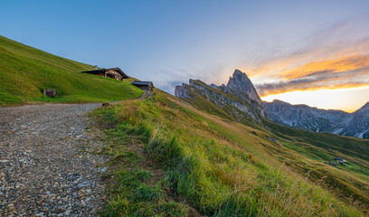 Sunrise at Seceda, Dolomites, Italy, Golden hues kiss the rugged landscape, unveiling a breathtaking spectacle as morning light paints the iconic peaks, and meadows aglow with warmth and radiance