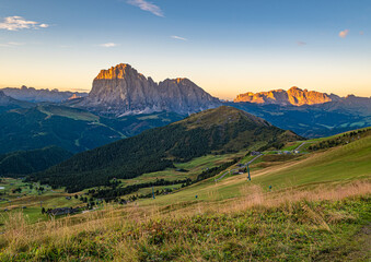 Golden sunrise at Seceda, Dolomites, Italy, A breathtaking scene unfolds, casting warm hues on the rugged landscape and meadows, creating a serene and radiant morning panorama