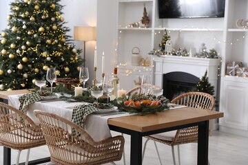 Christmas table setting with festive decor and dishware in living room