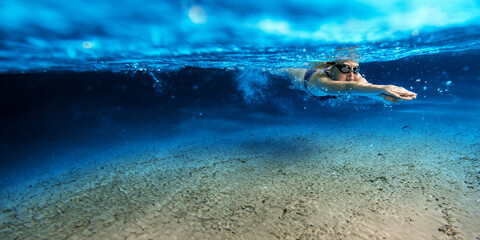 Une femme nageant sous l'eau dans la mer, photo sous-marine