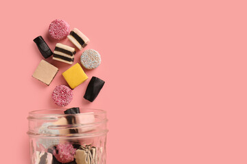 Jar with tasty liquorice candies on pink background, top view. Space for text