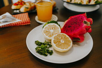 Appetizer table with Italian antipasti snacks and orange juice in glasses. Sliced ​​fresh lemon...