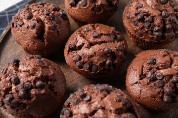 Tasty chocolate muffins on wooden board, closeup