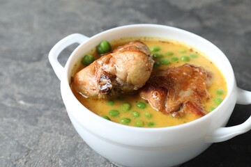 Tasty cooked rabbit meat with sauce and peas on grey table, closeup