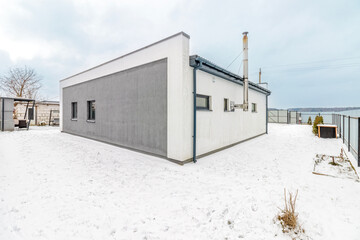 Modern one-storey house with a flat roof in winter