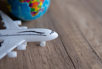 Closeup image of toy plane and earth globe on table with copy space. Travel concept.