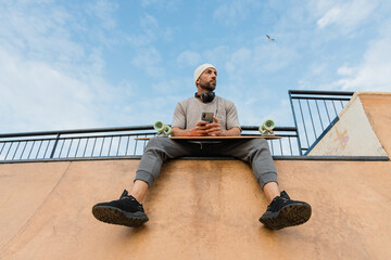 Male skater sitting on ramp