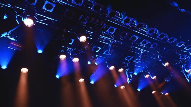 bright blue ceiling spotlights lights the stage during the musical concert or show