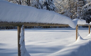 Schneebedecker Holzzaun nach starkem Neuschnee