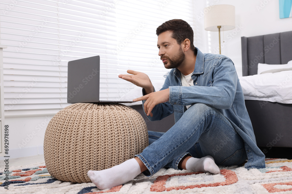 Canvas Prints Man blowing kiss during video chat via laptop at home. Long-distance relationship