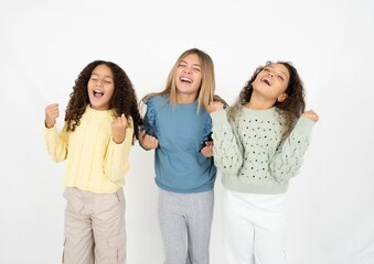 multi racial group of girl friends celebrating surprised and amazed for success with arms raised and eyes closed. Winner concept.