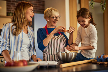 Three generations in the kitchen, lovely grandma, mother, and daughter cooking together. - obrazy, fototapety, plakaty