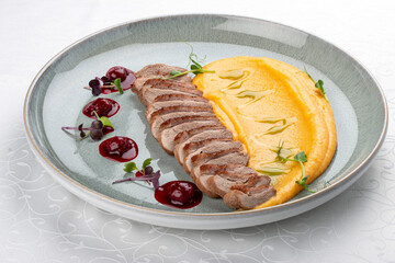 Duck breast, with pumpkin puree, cherry sauce and peanuts. Isolated image
