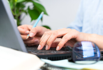 A young woman works at a computer. Close-up. Selective focus.