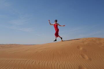 Woman in red dress on sand dunes