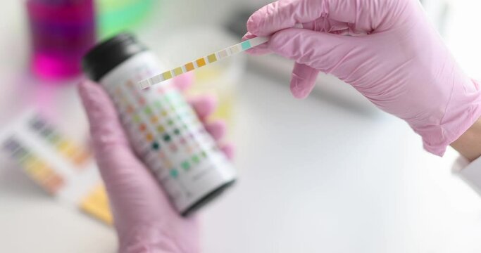 Hands in gloves hold test strips, close-up, slow motion. water ph indicator, medical laboratory, diabetes