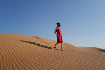 Woman in red dress on sand dunes