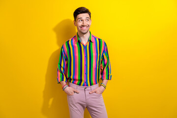Portrait of young happy guy thinking looking empty space curious choosing new outfit for nightclub isolated on yellow color background