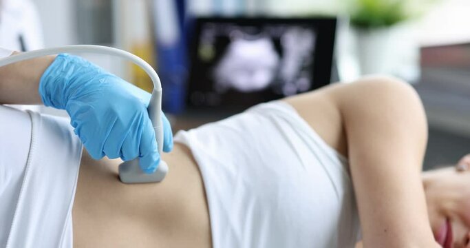 The doctor makes an ultrasound of the kidneys to a woman, close-up. Diagnosis of diseases of the adrenal glands