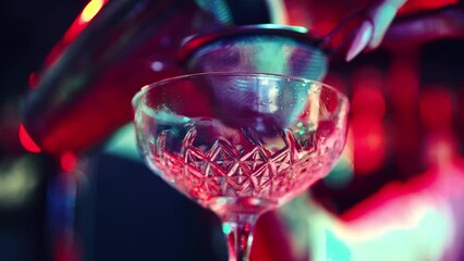 Focus on cocktail glass. Young girl, bartender working in bar, nightclub, making sweet and sour cocktail. Concept of nightlife, bar, party, alcohol drink, mixologist