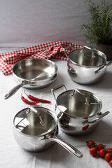 Set of stainless pots with lids and vegetables