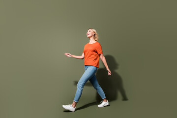 Fototapeta na wymiar Full body photo of attractive young woman going walk black friday dressed stylish orange clothes isolated on khaki color background
