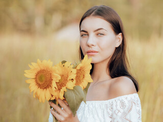 Close up portrait of beautiful woman holding sunflower. Nature and outdoor concept. Summer time. Beautiful face. Romantic mood.